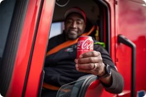 Man in red truck holding Coca-Cola can