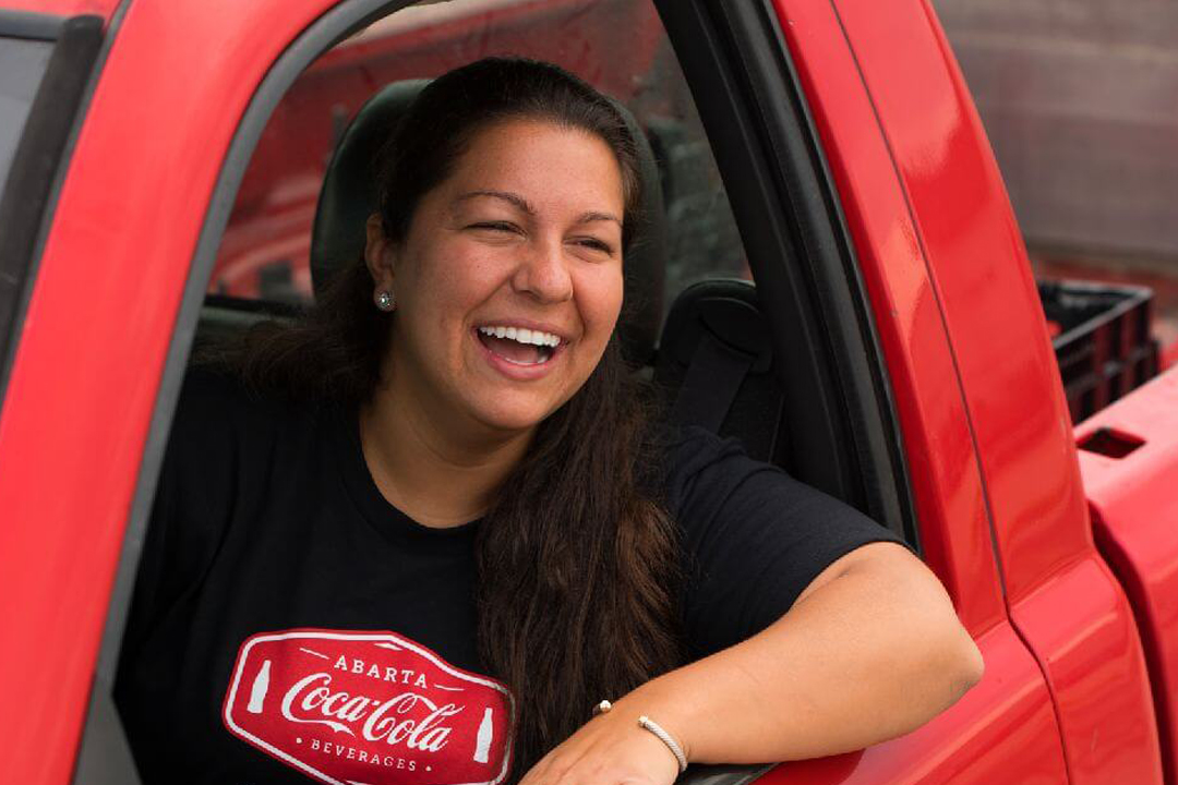 Woman in Abarta Coca-Cola shirt sitting in a red truck